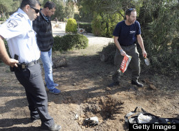A bomb technician collects the remains of a rocket launched from Gaza Strip falling close to Sderot on April 3, 2013. (Photo by DAVID BUIMOVITCH/AFP/Getty Images)