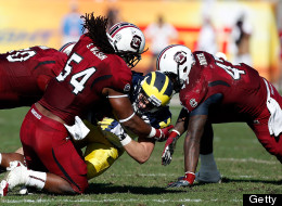 Receiver Drew Dileo #9 of the Michigan Wolverines gets a first down on a fake punt as defenders Chaz Sutton #90, Shaq Wilson #54 and Reginald Bowers #47 of the South Carolina Gamecocks close in for the tackle during the Outback Bowl Game at Raymond James Stadium on January 1, 2013 in Tampa, Florida. (Photo by J. Meric/Getty Images)