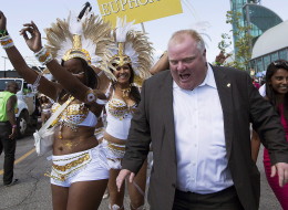 Toronto Mayor Rob Ford shows up an hour late, missing the ribbon cutting ceremony, as he briefly dances with paraders at the The Scotiabank Toronto Caribbean Carnival in Toronto on Saturday, August 3, 2013. (THE CANADIAN PRESS/Michelle Siu)