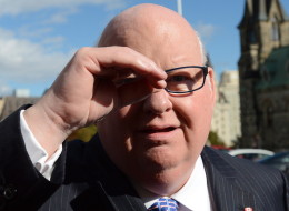 Sen. Mike Duffy shields his eyes as he arrives at the Senate on Parliament Hill in Ottawa on Oct. 22. (THE CANADIAN PRESS/Sean Kilpatrick)