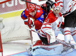 Russia's Vyacheslav Osnovin, left, is checked into the net behind Canada's goalie Zachary Fucale during the World Junior Hockey Championships bronze match between Canada and Russia at Malmo Arena in Malmo, Sweden, Sunday, Jan. 5, 2014. (AP Photo/Ludvig Thunman, TT News Agency)