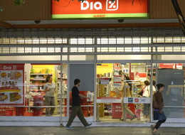 People walk past a supermarket with a promotional poster on its window in Buenos Aires on February 19, 2013. Argentines fear inflation may reach a rate of 30% this year, after a new price freeze has gone into effect until April 1. AFP PHOTO / JUAN MABROMATA (Photo credit should read JUAN MABROMATA/AFP/Getty Images)