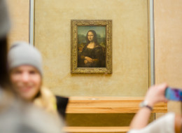 A historian has revealed his new theory on why Mona Lisa is smiling. Here, visitors take pictures of Leonardo da Vinci 'Mona Lisa' inside the Louvre museum on Feb. 28 in Paris.