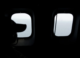 Search for Flight MH370: A crew member looks out the windows from a Malaysian Air Force CN235 aircraft during a search to find the missing Malaysia Airlines flight (MOHD RASFAN/AFP/Getty Images)