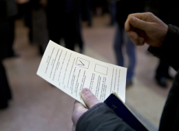 A man holds a ballot after casting a vote in favor of separation from Ukraine in the Crimean referendum in Simferopol, Ukraine, Sunday, March 16, 2014. (AP Photo/Vadim Ghirda)