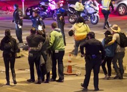 People walk away after the accident on Red River Street in downtown Austin, Texas, that left two dead at SXSW on Wednesday March 12, 2014. Police say a man and woman have been killed after a suspected drunken driver fleeing from arrest crashed through barricades set up for the South By Southwest festival and struck the pair and others on a crowded street. (AP Photo/Austin American-Statesman, Jay Janner)