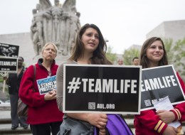Anti-abortion demonstrators hold signs during a Priests for Life protest outside the US Court of Appeals for the DC Circuit Court as the Court hears the oral arguments in the 'Priests for Life v. US Department of Health and Human Services (HHS)' case in Washington, DC, on May 8, 2014. (SAUL LOEB/AFP/Getty Images)