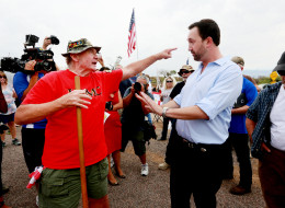 Adam Kwasman, a Tea Party patriot running for congress (R), has a heated discussion with an anti-immigration activist during a protest along Mt. Lemmon Road in anticipation of buses carrying illegal immigrants on July 15, 2014 in Oracle, Arizona. (Sandy Huffaker/Getty Images)