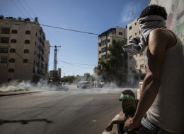 Palestinian supporters of Hamas take shelter while clashing with Israeli security forces on July 25, 2014 near Ramallah, West Bank.(Andrew Burton/Getty Images)