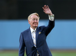 In this file photo, Dodger broadcaster Vin Scully waves to the crowd before throwing out the first pitch during ceeremonies honoring him on his 64 years of service. (Photo by Stephen Dunn/Getty Images)
