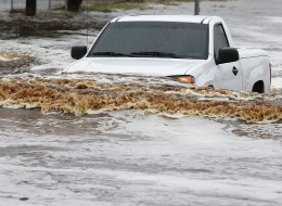 A pick-up truck driver tries to navigate a severely flooded street as heavy rains pour down Monday, Sept. 8, 2014, in Phoenix. Storms that flooded several Phoenix-area freeways and numerous local streets during the Monday morning commute set an all-time record for rainfall in Phoenix in a single day. (AP Photo/Ross D. Franklin)