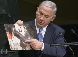 Israel's Prime Minister Benjamin Netanyahu points to a photo he says shows rocket launchers placed in residential neighborhoods of Gaza, as he addresses the 69th session of the United Nations General Assembly at U.N. headquarters, Monday, Sept. 29, 2014. (AP Photo/John Minchillo)