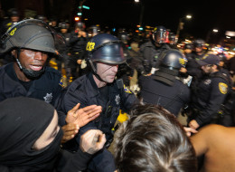 OAKLAND, CA - DECEMBER 13: Police officers push back protesters during a 'Millions March' demonstration protesting the killing of unarmed black men by police on December 13, 2014 in Oakland, California. The march was one of many held nationwide. (Photo by Elijah Nouvelage/Getty Images)