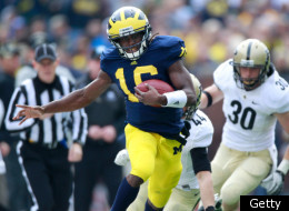 ANN ARBOR, MI - OCTOBER 29: Denard Robinson #16 of the Michigan Wolverines tip toes up the sideline in front of Joe Holland #30 and Landon Feichter #44 of the Purdue Boilermakers during a fourth quarter run at Michigan Stadium on October 29, 2011 in Ann Arbor, Michigan. (Photo by Gregory Shamus/Getty Images)