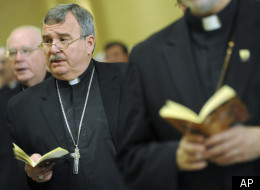 Bishop John R. Manz, second left, Auxiliary Bishop of Chicago, prays during the U.S. Conference of Catholic Bishops' annual fall meeting Nov. 16, 2010 in Baltimore.