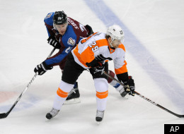Colorado Avalanche center Paul Stastny, left, and Philadelphia Flyers left wing Harry Zolnierczyk, right, battle for control of the puck in the second period of an NHL hockey game on Monday, Dec. 19, 2011, in Denver. (AP Photo/Chris Schneider)