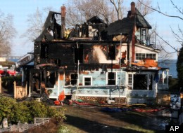 Firefighters investigate a house where an early morning fire left five people dead Sunday, Dec. 25, 2011, in Stamford, Conn. Officials said the fire, which was reported shortly before 5 a.m., killed two adults and three children. Two others escaped. Their names have not been released. (AP Photo/Tina Fineberg)