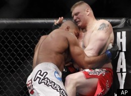 Brock Lesnar is pushed into the octagon by Alistair Overeem of the Netherlands during their UFC heavyweight mixed martial arts match Friday, Dec. 30, 2011 at The MGM Grand Garden Arena in Las Vegas. Overeem won TKO when the fight was stopped by the referee. (AP Photo/Eric Jamison)