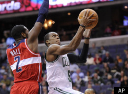 Boston Celtics guard Rajon Rondo, right, goes to the basket against Washington Wizards guard John Wall (2) during the first half of an NBA basketball game, Sunday, Jan. 1, 2012, in Washington. The Celtics won 94-86. (AP Photo/Nick Wass)