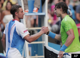 Spain's Rafael Nadal shakes hands with Alex Kuznetsov, left, of the US following their first round match at the Australian Open tennis championship, in Melbourne, Australia, Monday, Jan. 16, 2012. (AP Photo/Rick Rycroft)