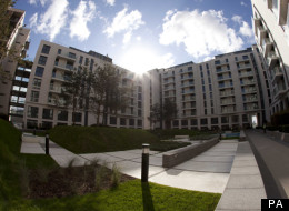 In this photo taken with a fish-eye lens, the sun shines above structurally completed apartments at the Olympic Village in the Olympic Park in east London,