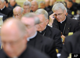 Bishop Paul Coakley, right, of Salina, Kan., prays during the U.S. Conference of Catholic Bishops' annual fall meeting in 2010 in Baltimore.