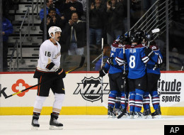Anaheim Ducks right wing George Parros, left, skates past the Colorado Avalanche as they celebrate a goal by left wing Cody McLeod in the first period of an NHL hockey game on Monday, Feb. 27, 2012, in Denver. (AP Photo/Chris Schneider)