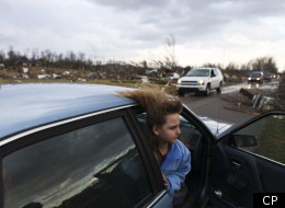 Une jeune fille, cheveux dans le vent, observe l'ampleur des dégâts, dans la ville de New Pekin. (AP Photo - Matt Stone)