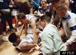 Duke's Christian Laettner, top, who scored the game-winning basket in overtime, celebrates with teammate Grant Hill on the floor of the Spectrum in Philadelphia Saturday, March 28, 1992, as teammates and fans crowd around. The defending national champions defeated the University of Kentucky 104-103 to advance to the final four. (AP Photo/Amy Sancetta)