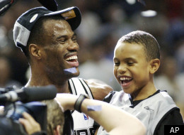 San Antonio Spurs' David Robinson holds his son Corey, 8, after the Spurs defeated the New Jersey Nets 88-77 to win the NBA Championship, Sunday, June 15, 2003.