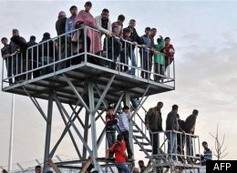Des réfugiés regardent ce qui se passe de l'autre côté de la frontière à Kilis, en Turquie. (AFP)