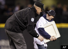 U.S. Army 1st Sgt. Steve Smerer surprises his son Kyle Smerer, 13, by dressing as an umpire and meeting the boy at second base during a base-stealing promotion between innings as the Seattle Mariners play the Oakland Athletics in a baseball game.