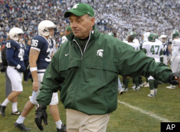 Michigan State coach John L. Smith, center, touches the hand of one of his players as he leaves the field after loosing 17-13 to Penn State in a football game Saturday, Nov. 18, 2006, in State College, Pa. Smith was fired as head coach and will not return next season. (AP Photo/John Beale)