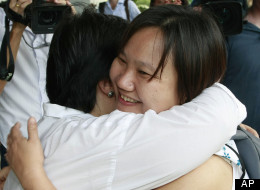 Chiranuch Premchaiporn, right, director of Thai newspaper website Prachatai, is greeted by an unidentified friend upon her arrival at the criminal court Monday, April 30, 2012, in Bangkok, Thailand. (AP Photo/Apichart Weerawong)