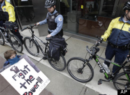 Chicago Police block the entrance to a Bank of America branch as about 50 Occupy Chicago activists gather outside, as part of a May Day demonstration, Tuesday, May 1, 2012, in Chicago. They accuse banks of profiting over the needs of ordinary people and decry Bank of America's federal bailout. (AP Photo/M. Spencer Green)