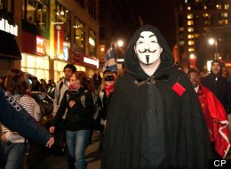 Protester wearing a Guy Fawkes mask in another nightime protest on Montreal city streets.