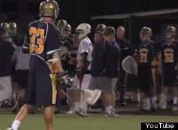 St. Thomas Aquinas lacrosse player Jake Champion punches an opposing player while being ecorted off the field.