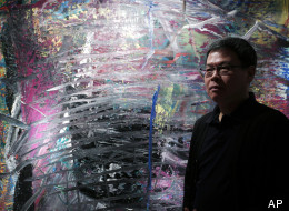 In this photo taken on Monday, April 2, 2012, Indonesian-Chinese farming tycoon Budi Tek poses in front of a painting by Gerhard Richter during an auction preview in Hong Kong. Tek is set to open the De Museum in Shanghai next year featuring Asian and Western contemporary art, after opening his first in Indonesia's capital Jakarta in 2008.