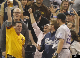 Colorado Rockies third baseman Jordan Pacheco, who lost a battle with a fan for a pop foul, looks at the fan holding up his beer where the ball ended up floating during the seventh inning of a baseball game Tuesday, May 8, 2012 in San Diego. (AP Photo/Lenny Ignelzi)