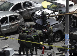 Police and firefighters work at the scene of a bomb in Bogota, Colombia, Tuesday, May 15, 2012. (AP Photo/Ricardo Mazalan)