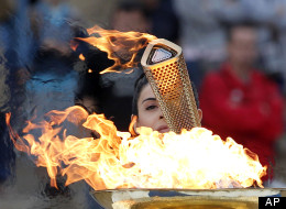 Actress Ino Menegaki, dressed as a high priestess, lights the torch at a ceremony in Panathinean stadium in Athens, Thursday, May 17, 2012. The torch begins its 70-day journey to arrive at the opening ceremony of the London 2012 Olympics. (AP Photo/Petros Giannakouris)