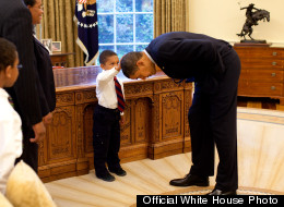 President Barack Obama bends over so the son of a White House staff member can pat his head during a family visit to the Oval Office May 8, 2009. The youngster wanted to see if the President's haircut felt like his own. (Official White House Photo by Pete Souza)