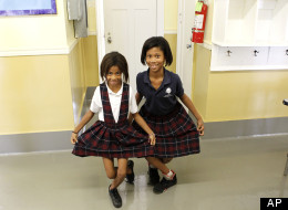 Alexandria Cole, 9. left, and Kaci Chairs, 9, right, curtsy in the hallway at the International School of Louisiana in New Orleans, Friday, Nov. 11, 2011.