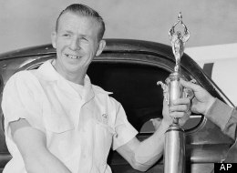Cotton Owens of Spartanburg, S.C., left, winner of the 100-mile modified and sportsmen stock car race over the beach road course in Daytona Beach on Feb. 14, 1953 receives a trophy from Mal Middleworth. (AP Photo/Jim Kerlin)