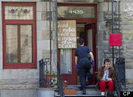 A police officer enters the home of Quebec MNA Amir Khadir following an early morning raid that left with the arrest of his daughter Yalda Machouf-Khadir and her boyfriend Thursday, June 7, 2012 in Montreal. The two were arrested on charges related to the ongoing student conflict against tuition hikes. (CP/Paul Chiasson)