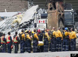 Rescue workers remove their hard hats as firefighters carry a second body out of the Algo Centre Mall in Elliot Lake, Ont., on Wednesday, June 27, 2012, after the mall's roof collapsed last Saturday. Provincial police in Ontario announce criminal investigation into the fatal mall roof collapse in Elliot Lake. THE CANADIAN PRESS/Nathan Denette