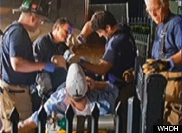 Rescue workers attempt to free a man impaled by a fence.