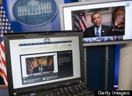 President Barack Obama participates in an interview with YouTube and Google from the Roosevelt Room of the White House in Washington, DC, January 30, 2012, as seen on a laptop in the Brady Press Briefing Room. (Saul Loeb / Getty)