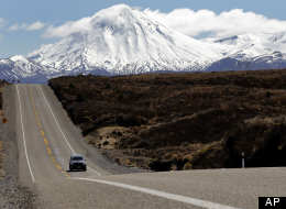 A car drives state highway 1 near the snowcapped mountains at Tongariro National Park in New Zealand, Wednesday, Sept. 28, 2011. (AP Photo/Christophe Ena)