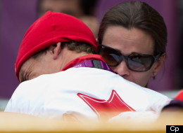 Canada's Simon Whitfield is hugged by his wife after crashing and retreating from the men's triathlon at Hyde Park during the Summer Olympics in London on Tuesday, August 7, 2012. (CP/Sean Kilpatrick)